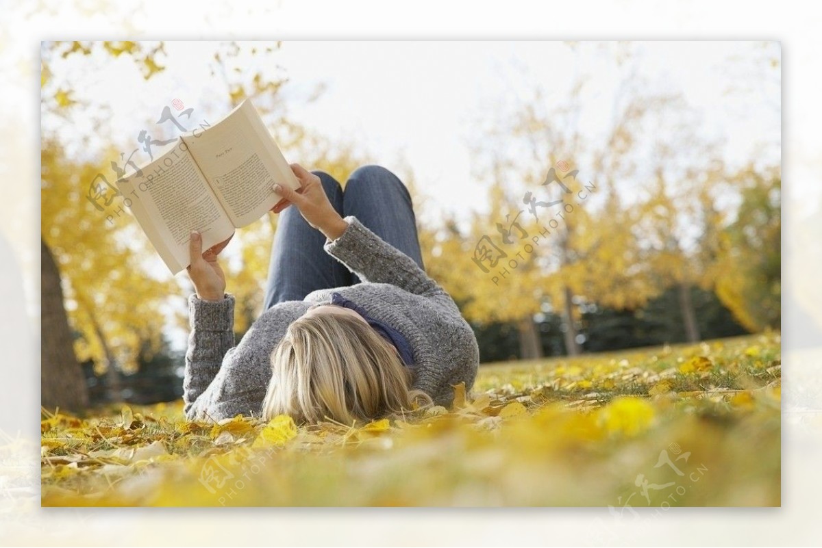 躺在秋天落叶上看书的女孩图片