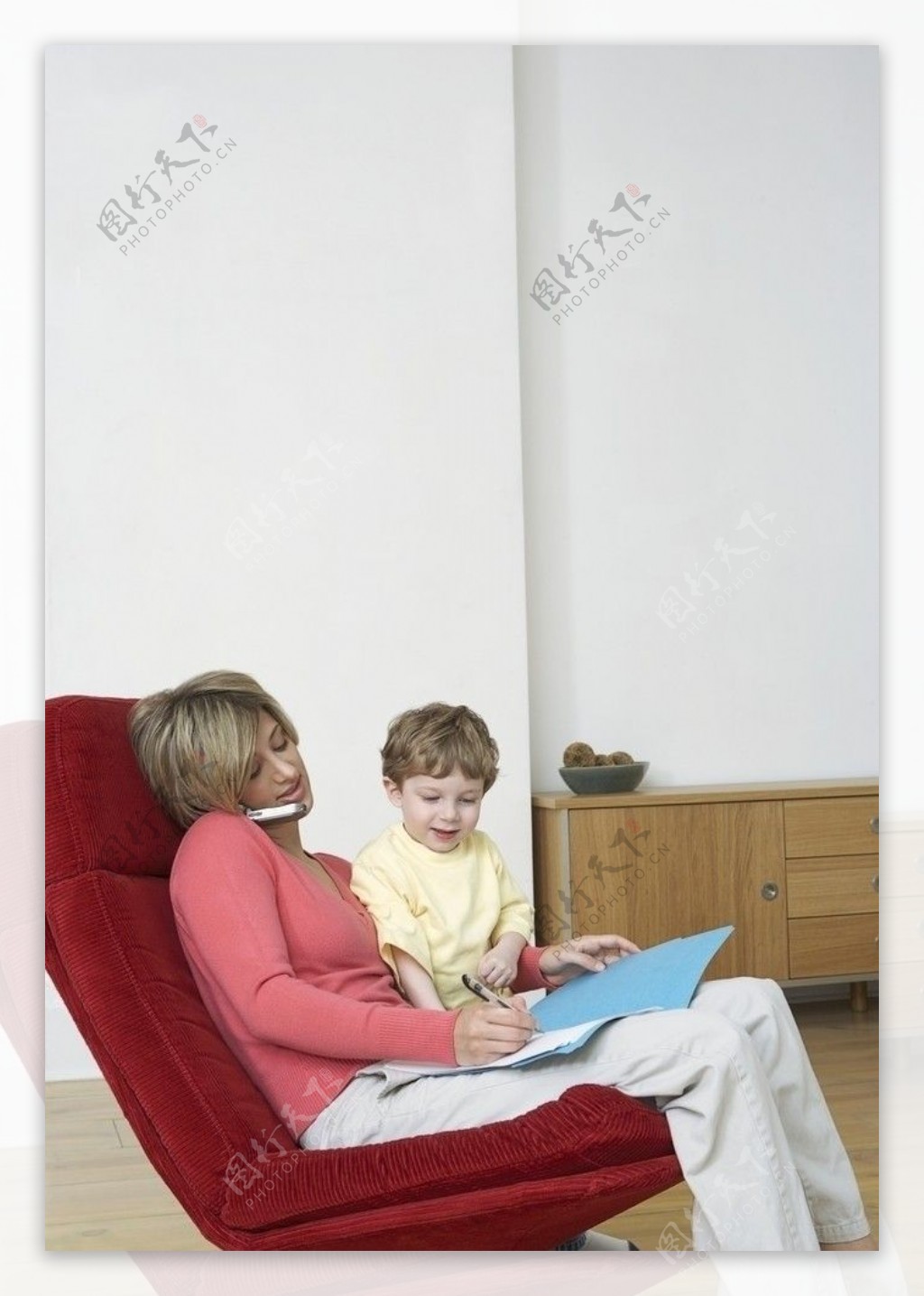 转椅上接电话记录的妈妈和儿子图片