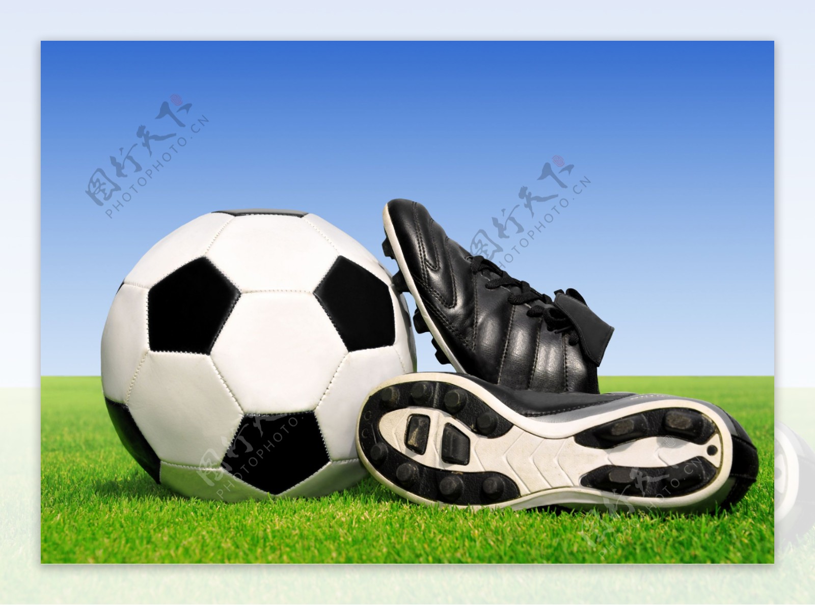 草地上的足球和球鞋图片