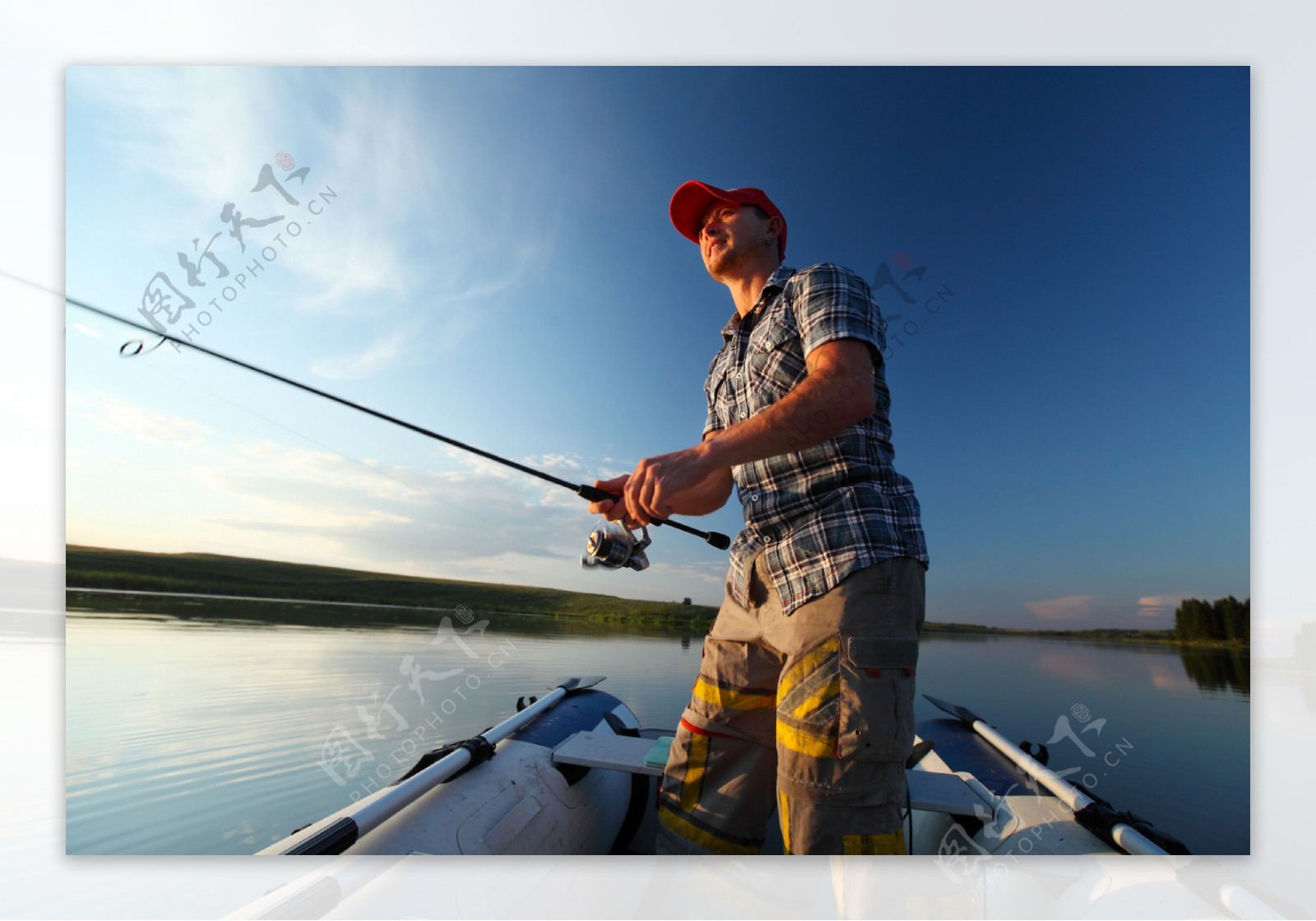 皮艇上钓鱼的男人图片
