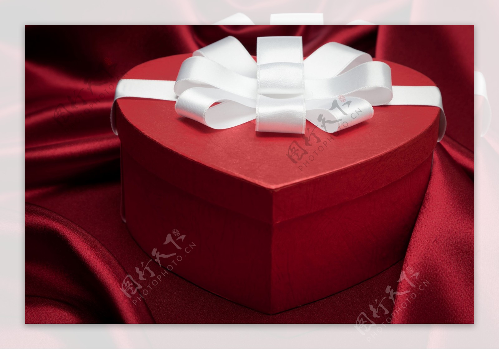 红色爱心礼盒与绸布背景图片