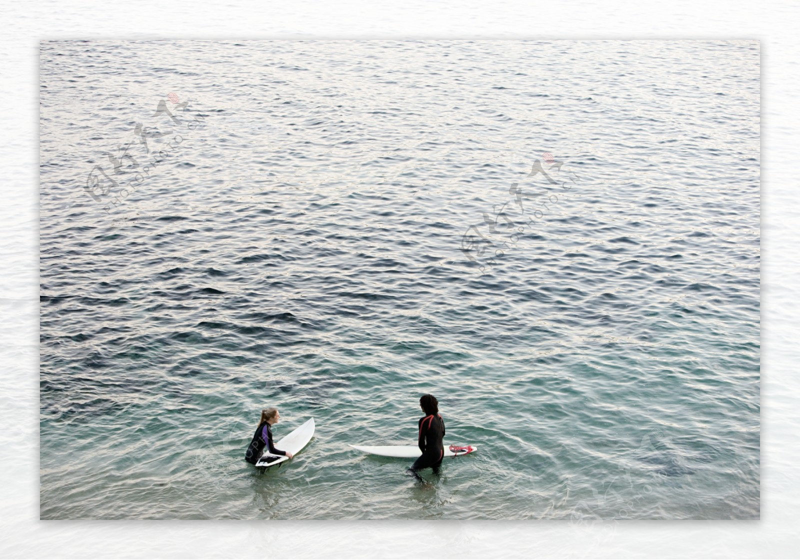 大海中拿冲浪板的人物图片