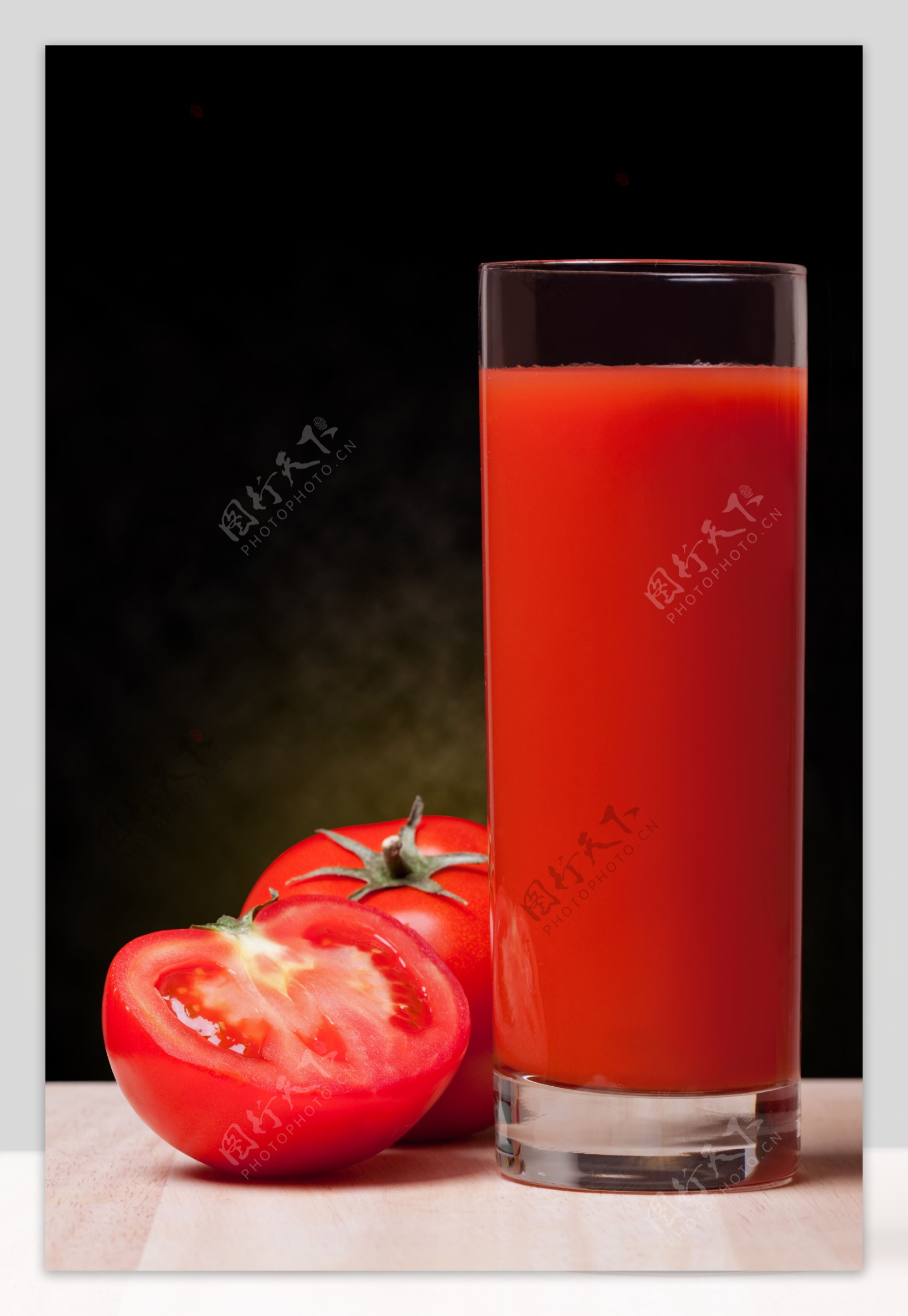 一杯果汁旁的西红柿图片