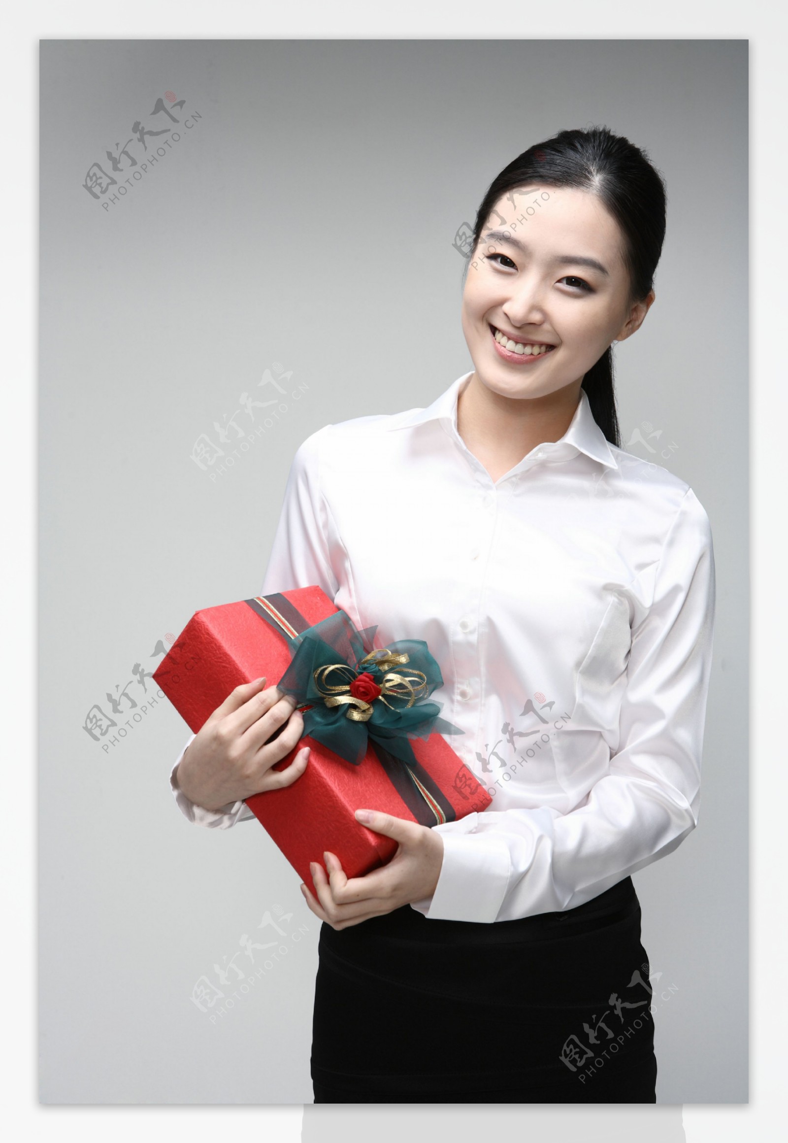 抱着礼物微笑的商务美女图片