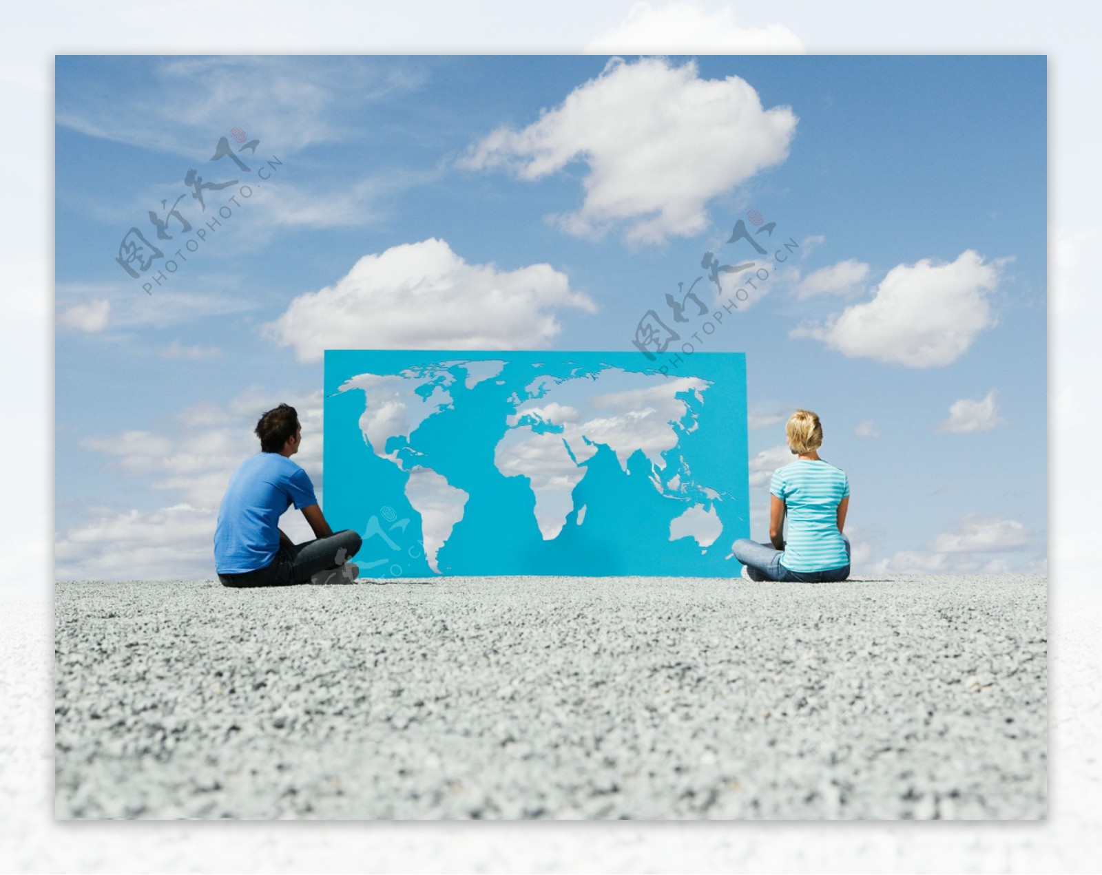 坐在地上的外国人与镂空世界地图图片