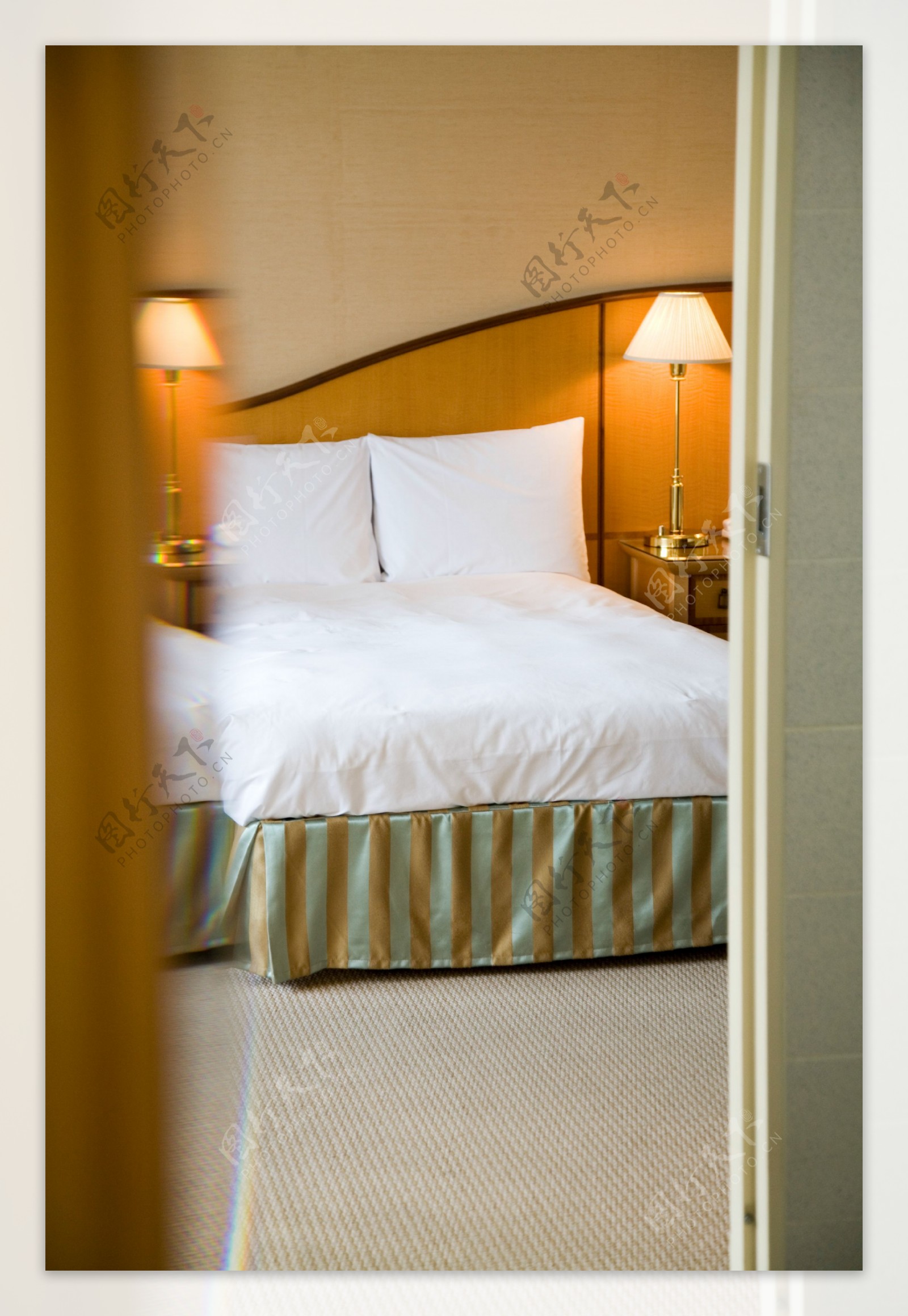 酒店客房内整洁的床和台灯图片