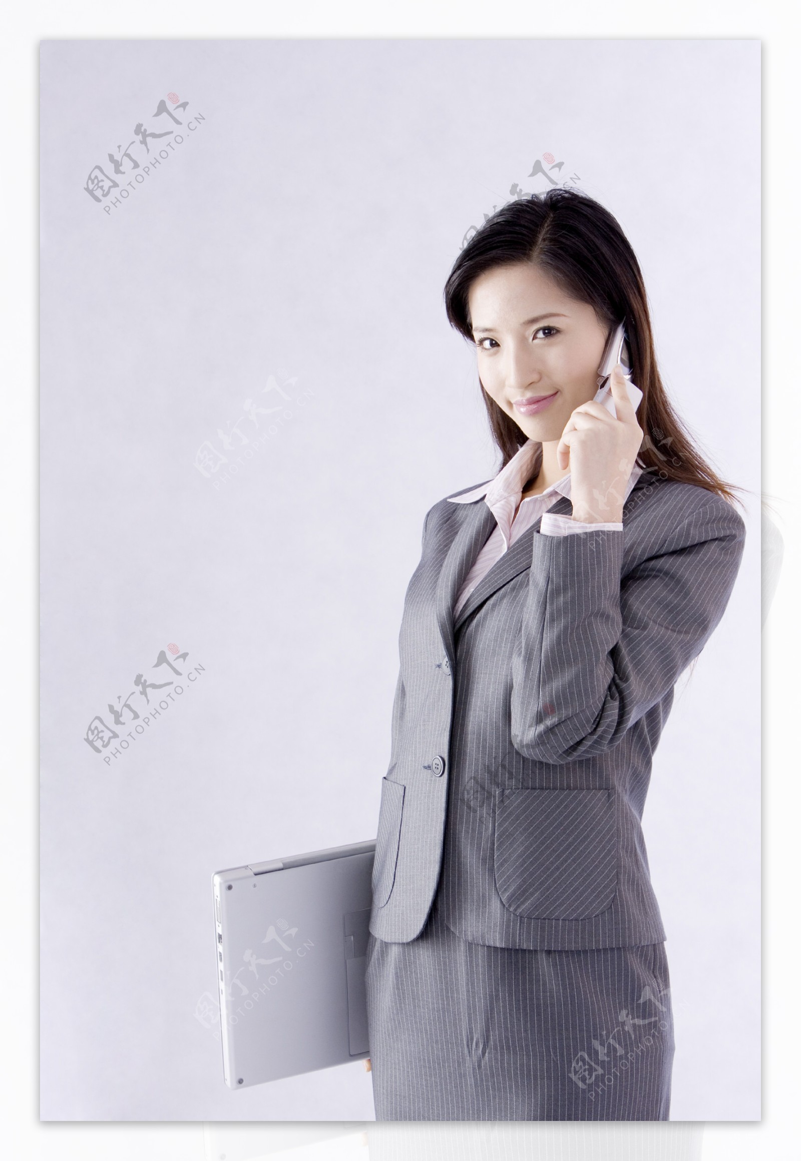 拿着笔记本打电话的商务女性图片图片