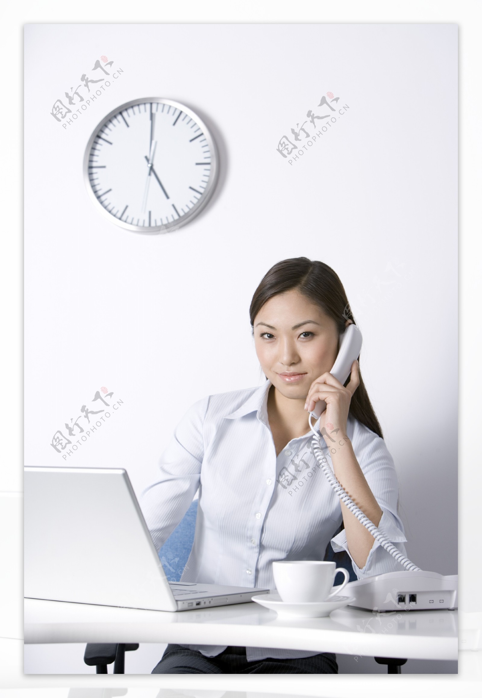 坐在办公桌前打电话的女性图片图片