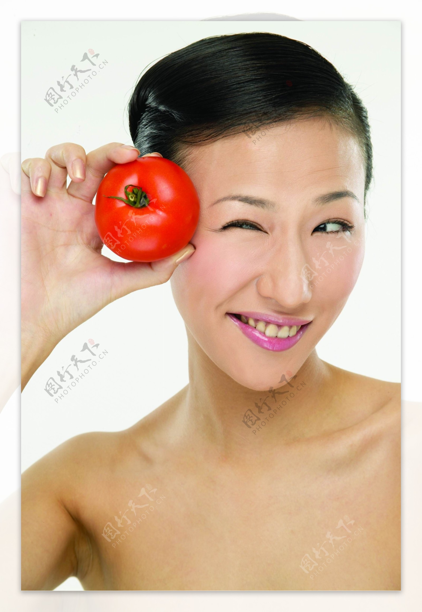 手拿蕃茄的健康女性图片