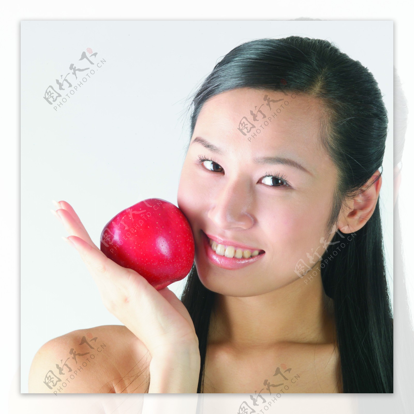 拿着苹果放在脸上的女孩图片