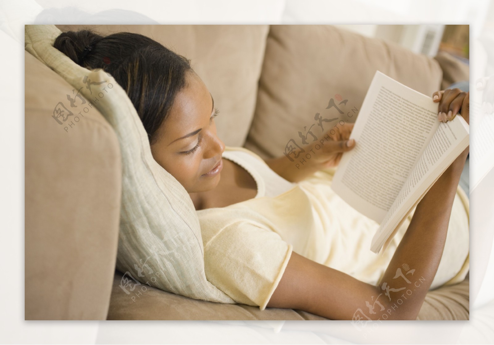 躺在沙发上看书的女性图片
