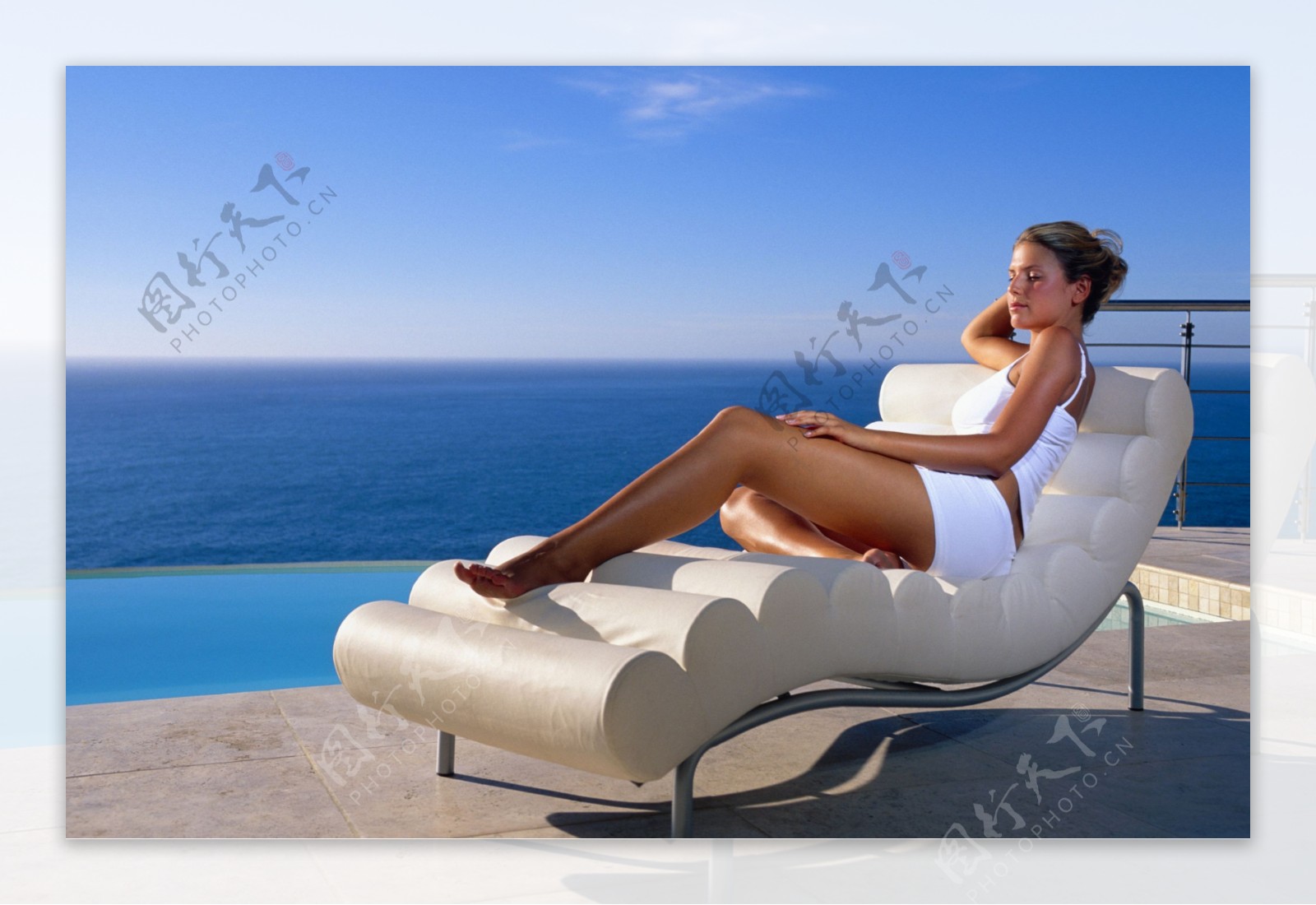躺椅上享受日光浴的女人图片