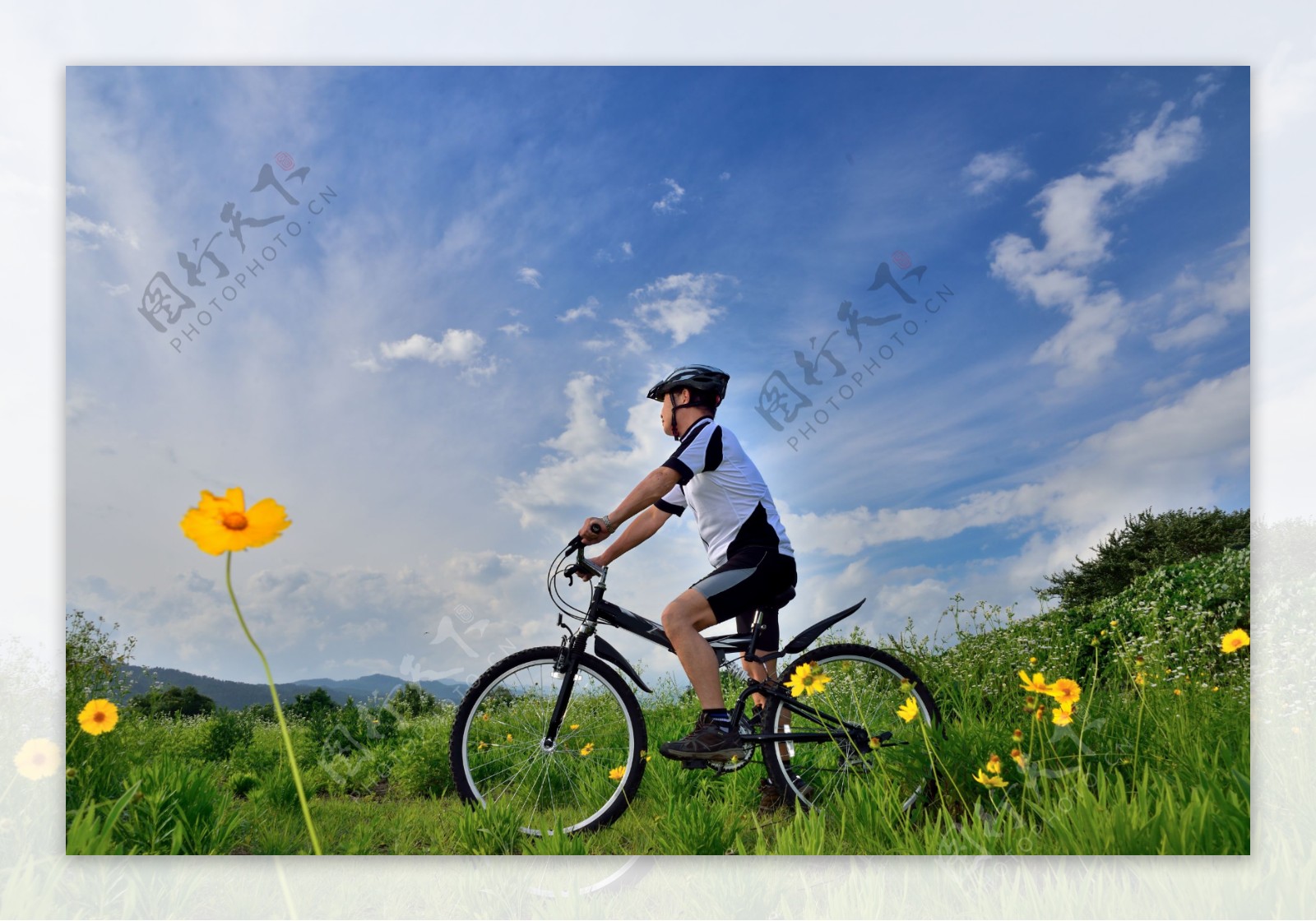蓝天下骑着自行车的人物图片