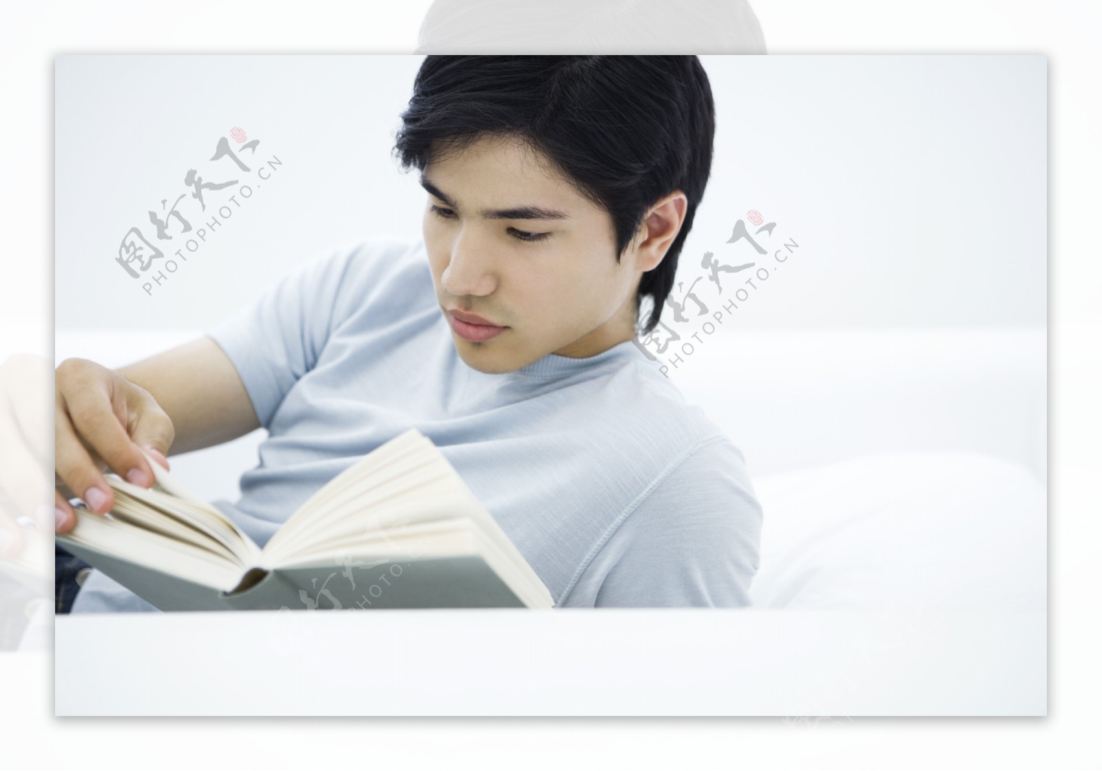 青年男人在院子里看书高清摄影大图-千库网