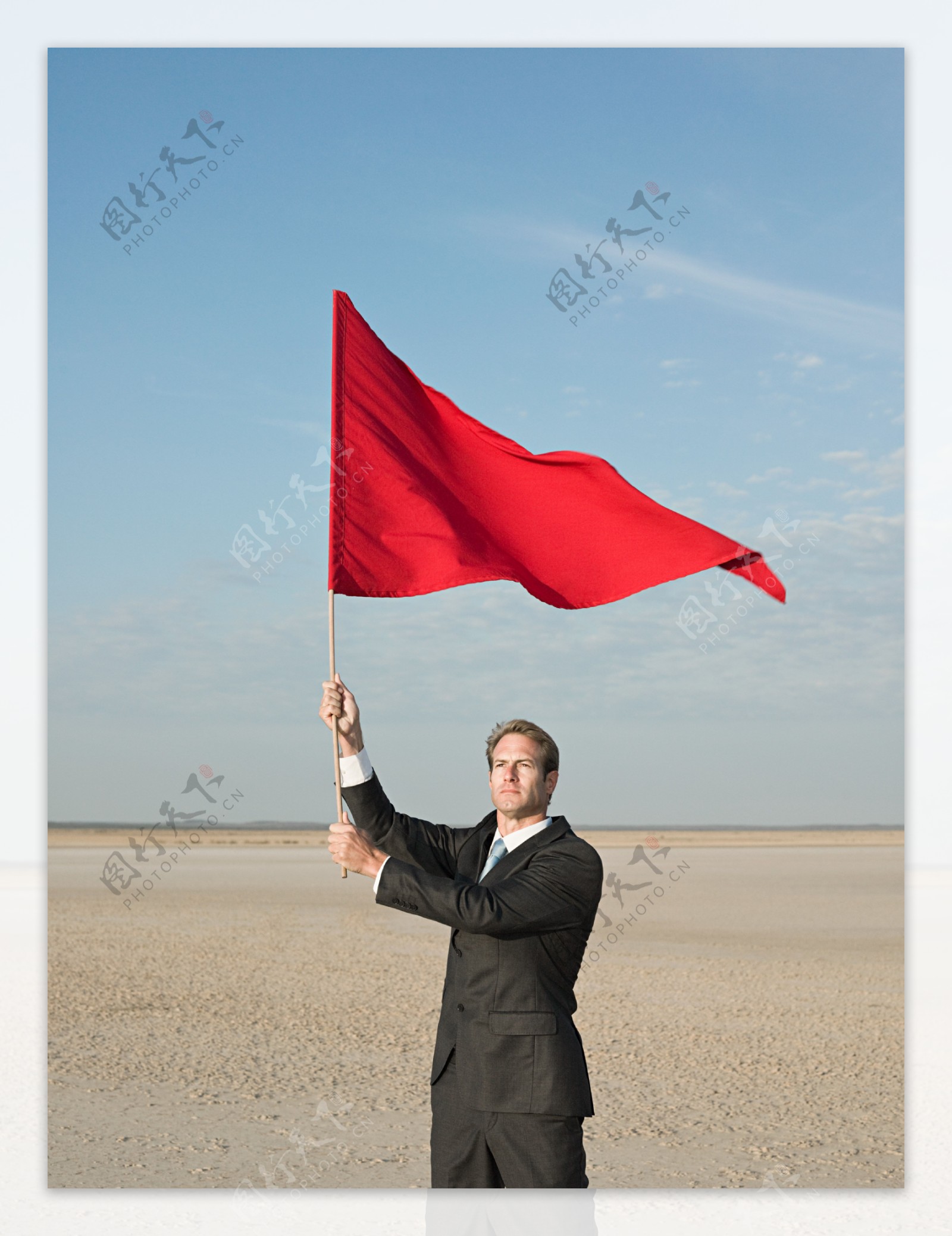 举着红旗仰望天空的外国商务男士图片