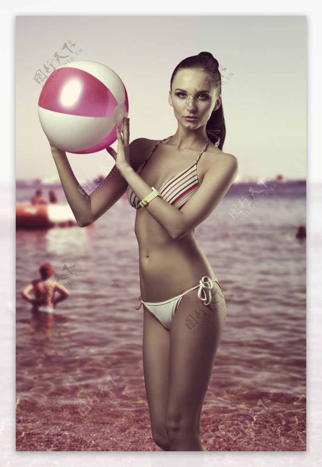 沙滩上拿着皮球的美女图片