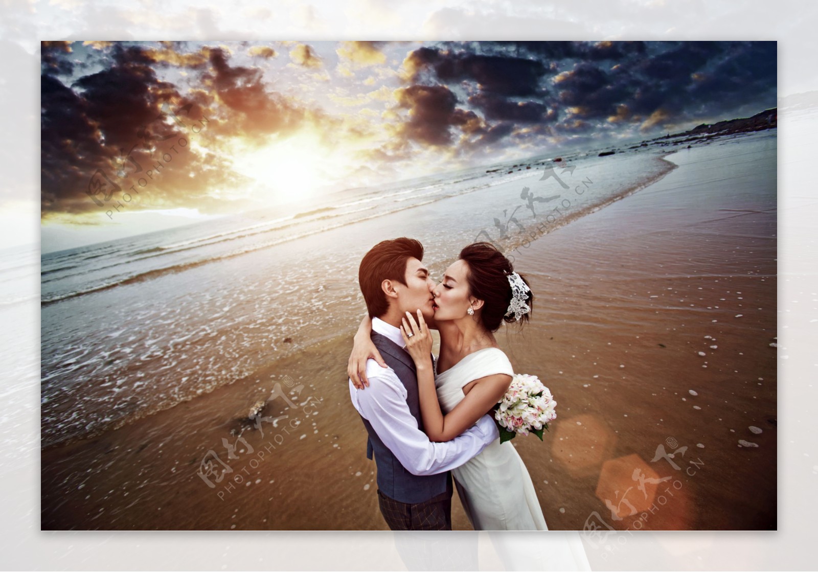 沙滩上接吻的婚纱情侣图片