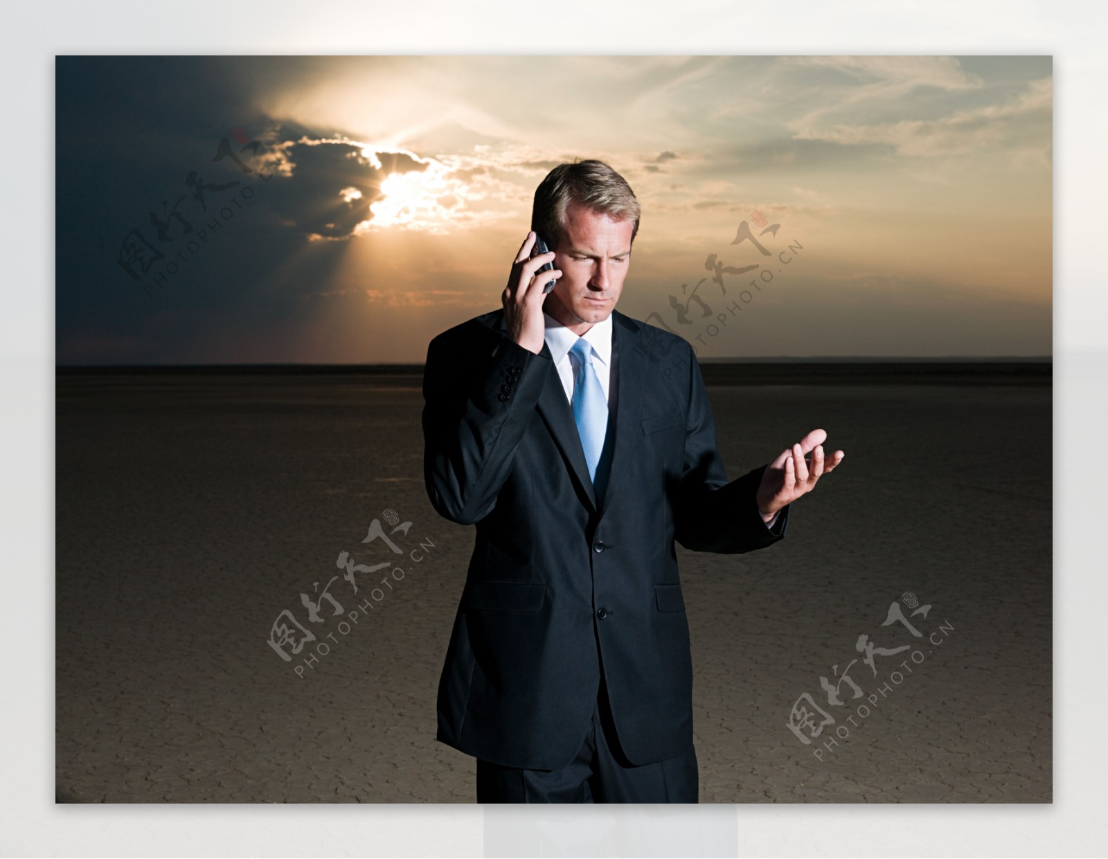 夕阳西下在打手机的外国男人图片