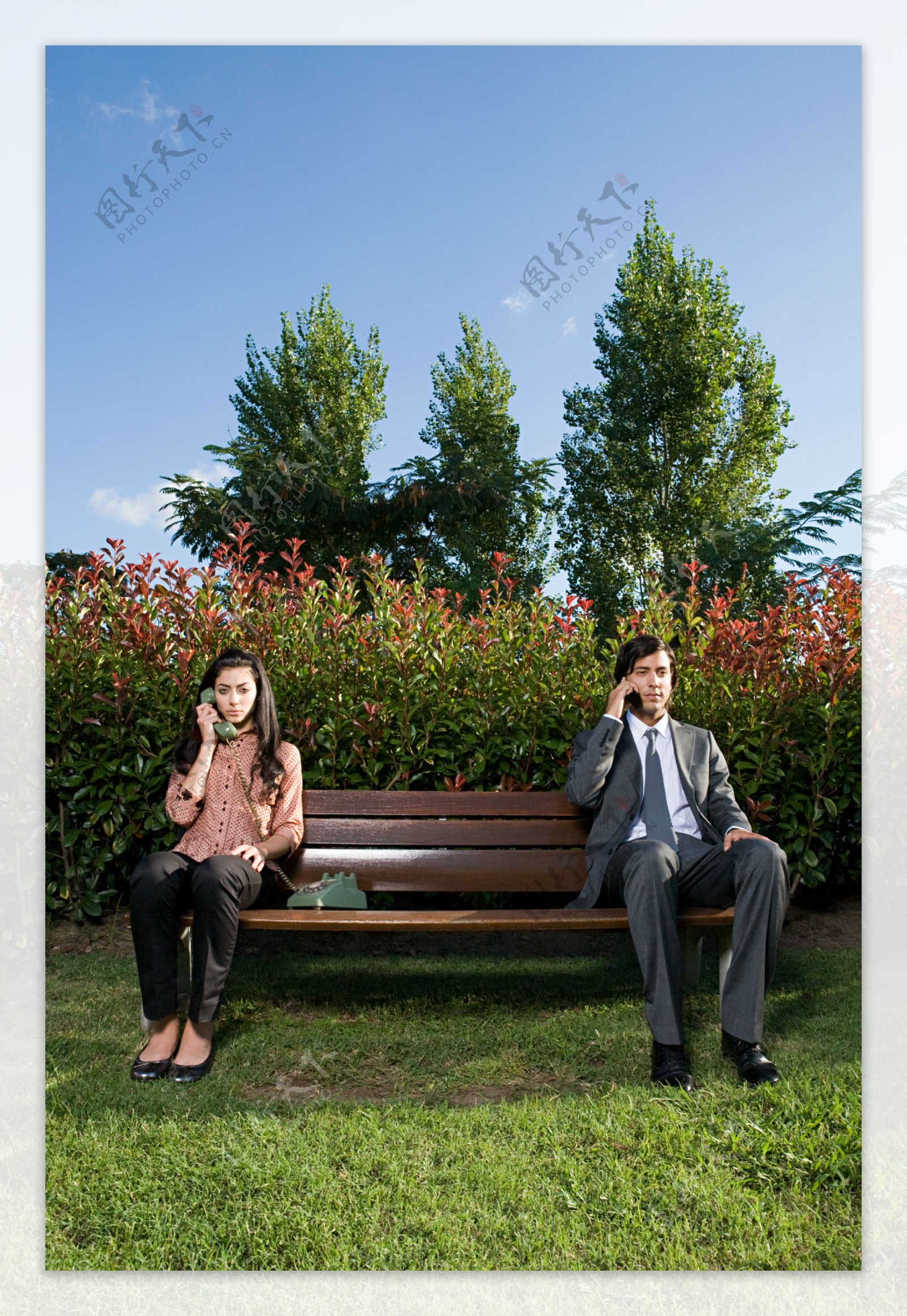 坐在长椅上打电话的男女图片