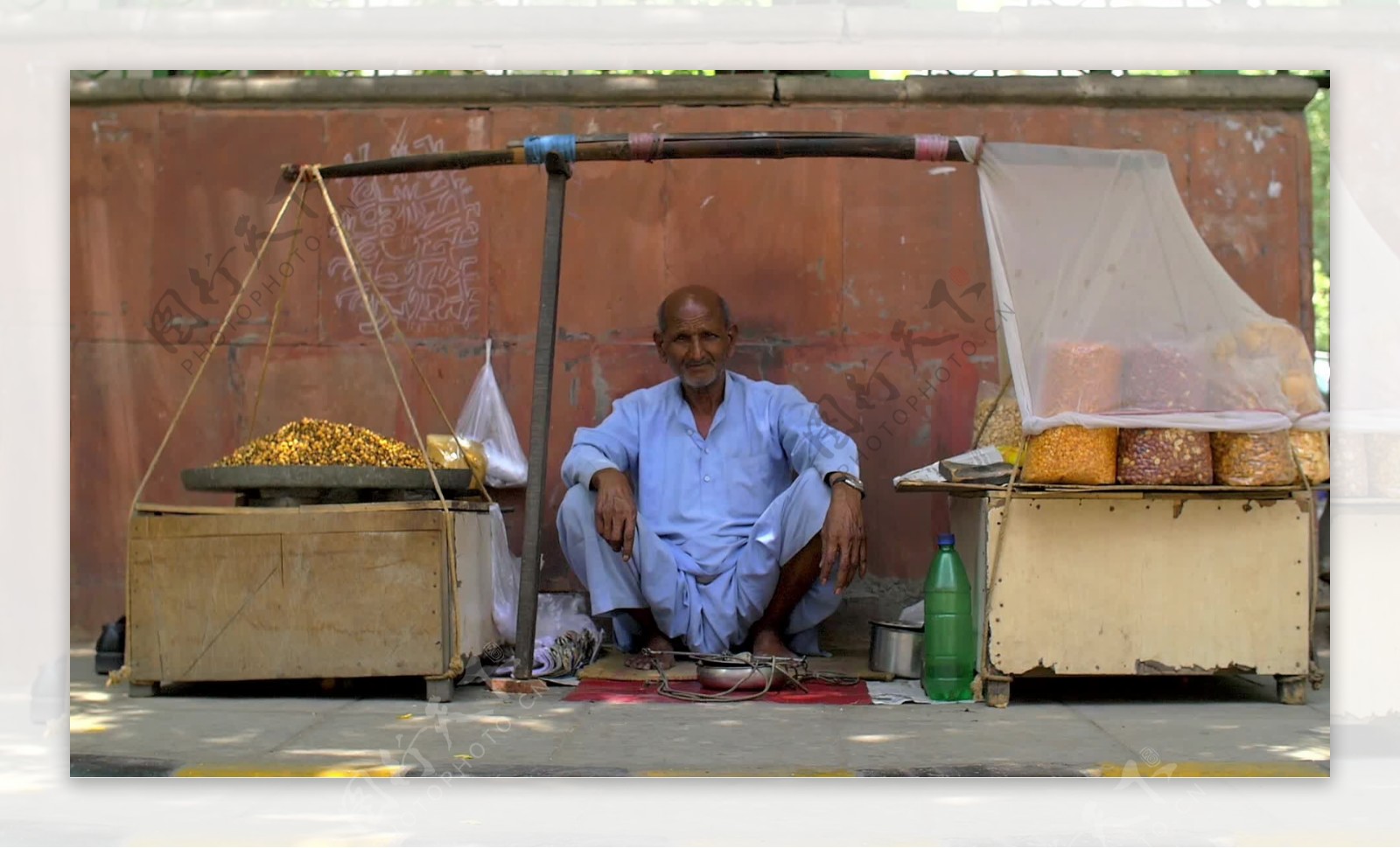 坐在印度街的食品摊上的老人