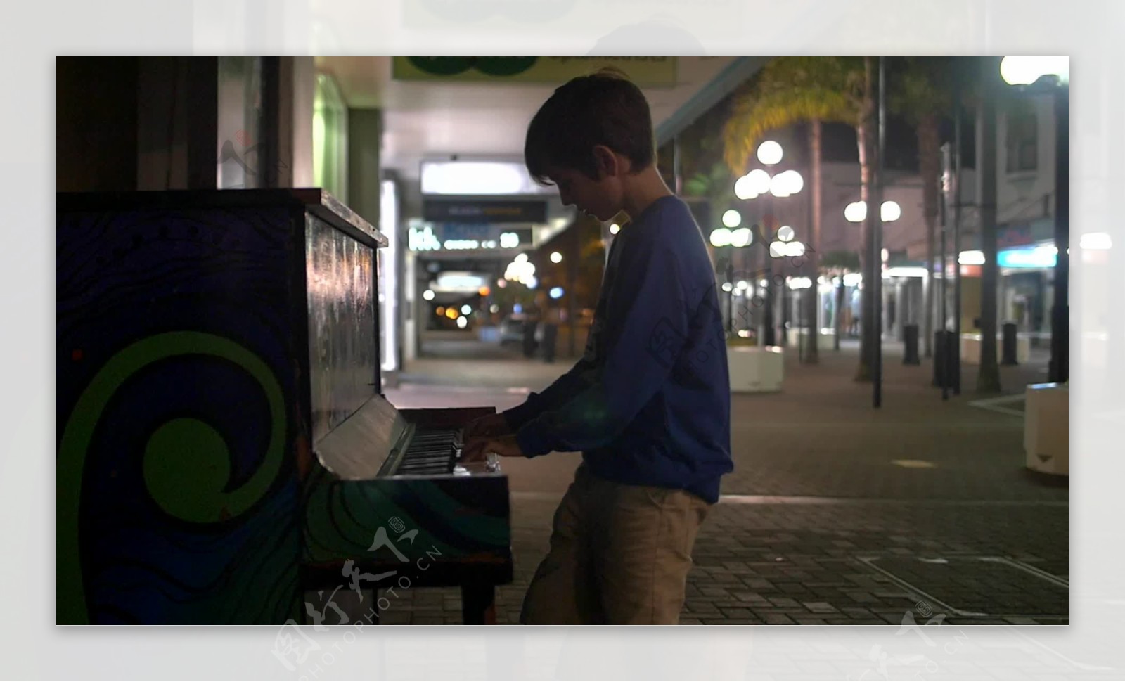 在街上弹钢琴的小男孩